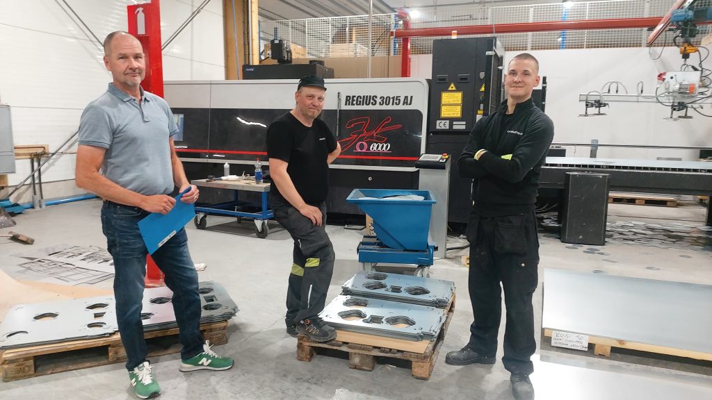 Rasekon ohjaaja Marko Suominen, Laser-Aitan Jussi Leino ja opiskelija Arttu Oja Amada Regius-kuitulaserleikkurin edessä