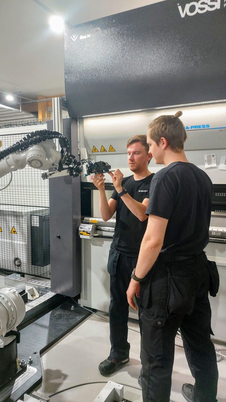 Mikko Toivonen ja Veikka Säteri Dyna-Cellin Kuka-teollisuusrobotin vieressä LAser-Aitan tiloissa