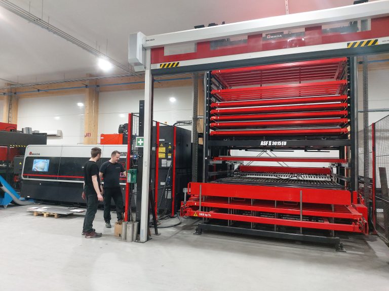 Amada Regius laserleikkauskone, etualalla kaksi Laser-Aitan työntekijää